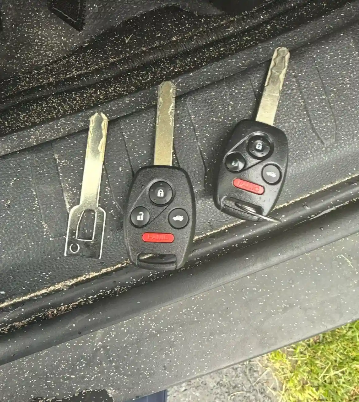 Three car keys, one broken, on a textured surface, representing AA Locksmith Near Me LLC's broken key extraction service.