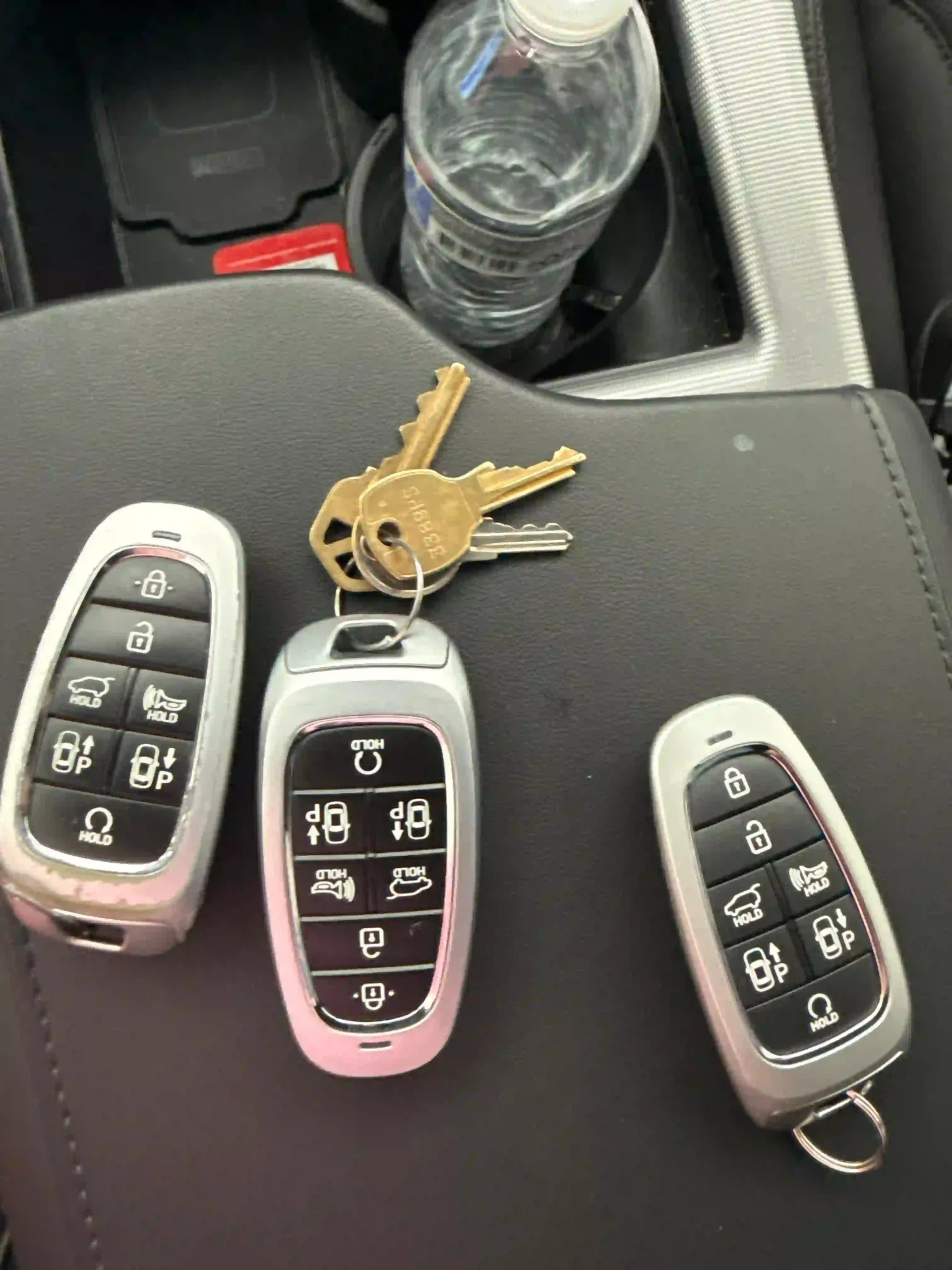 New car key fobs and keys on a car console after an ignition replacement service by AA Locksmith Near Me LLC.